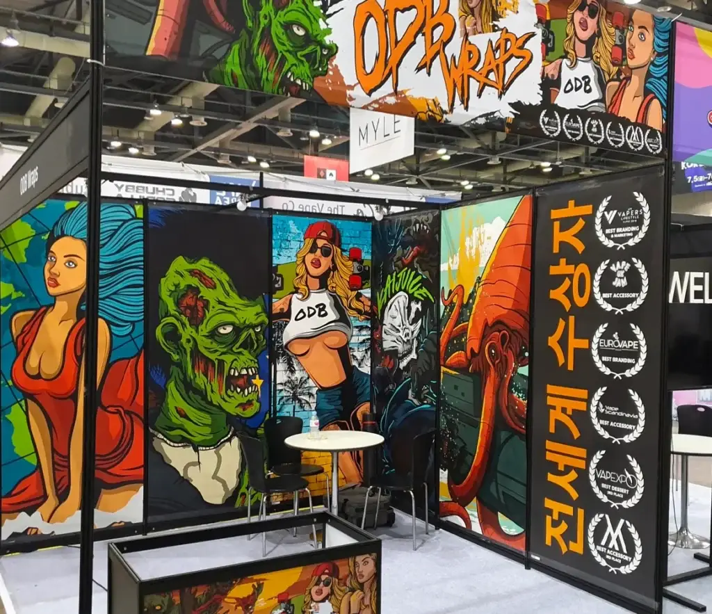 ODB Wraps exhibition stand: wall panels covered in large illustrated characters, with award laurels and seating